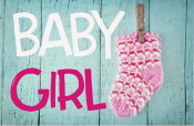 Roze baby sokje aan wasknijper, tekst "BABY GIRL" op blauwe houten achtergrond.