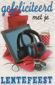 Gefeliciteerd met je lentefeest. Tablet met koptelefoon, horloge en rode mok met witte stippen op tafel.
